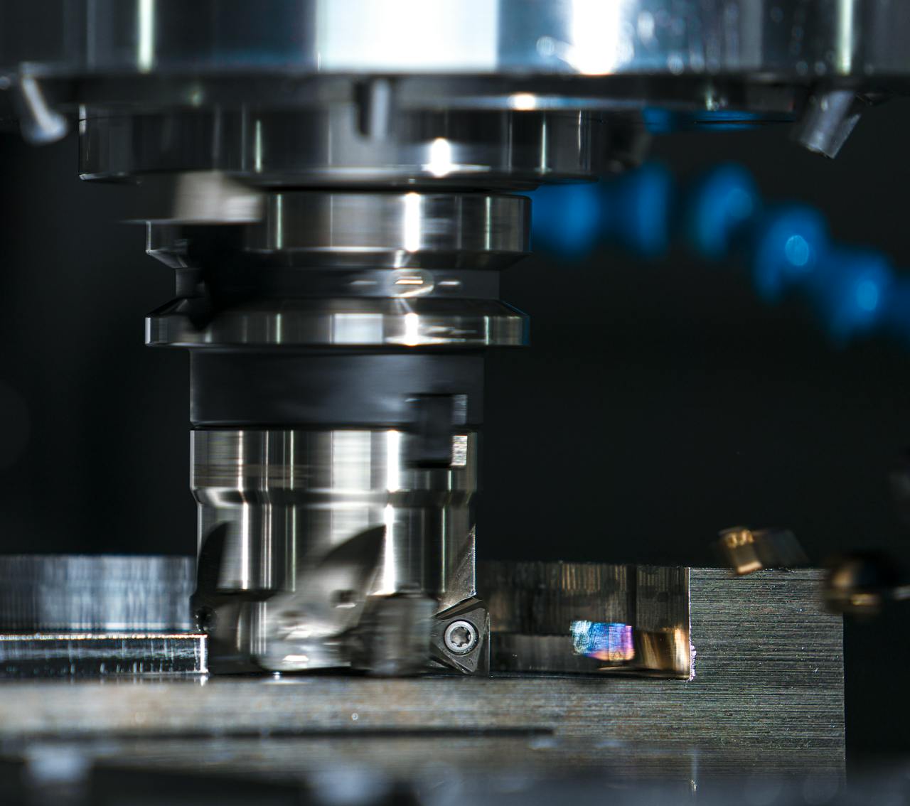 High-precision milling machine cutting a metal piece, showcasing industrial machinery.